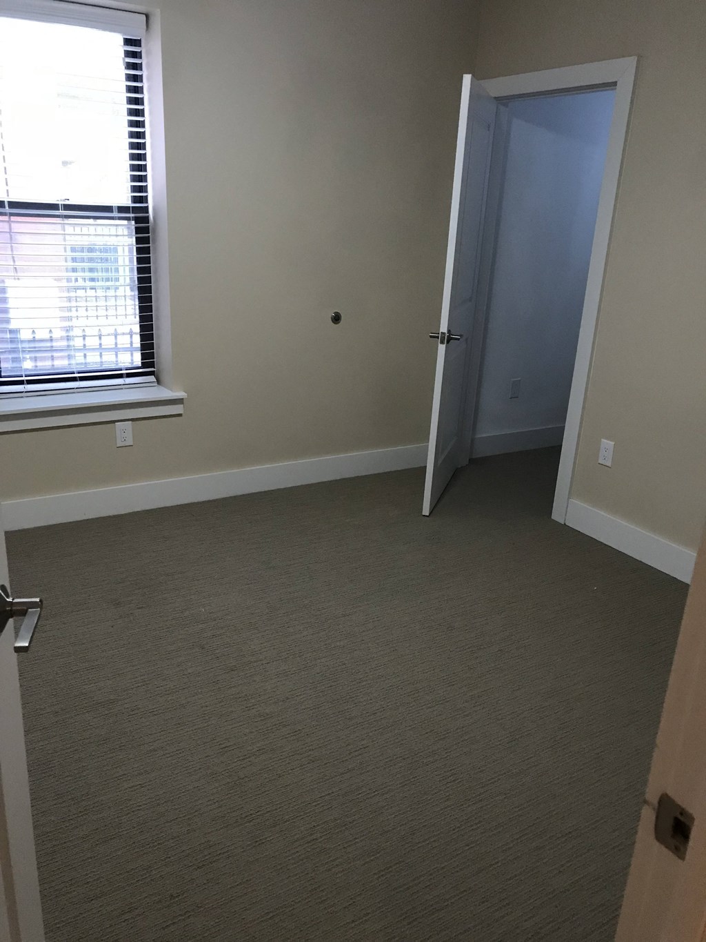 an empty room with a door and a window