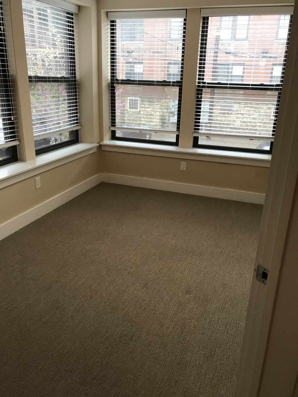 an empty room with three windows in it