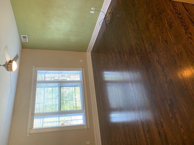an empty room with a window and a wooden floor