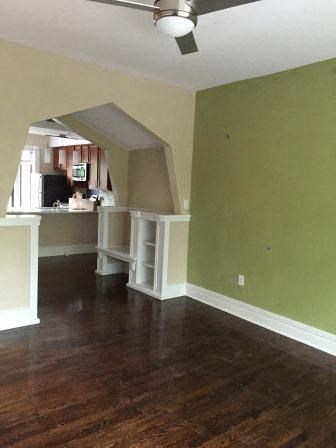 an empty living room and kitchen with a wood floor