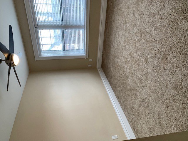 an empty room with a window and a fan