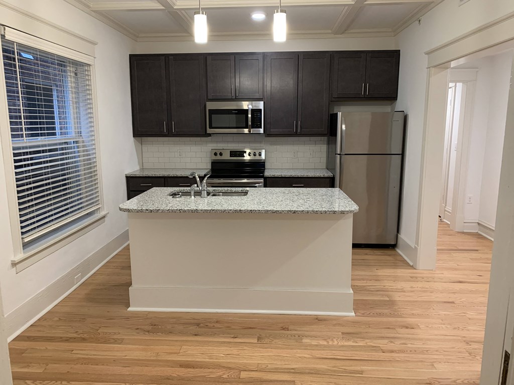 a kitchen with a island and a stainless steel refrigerator