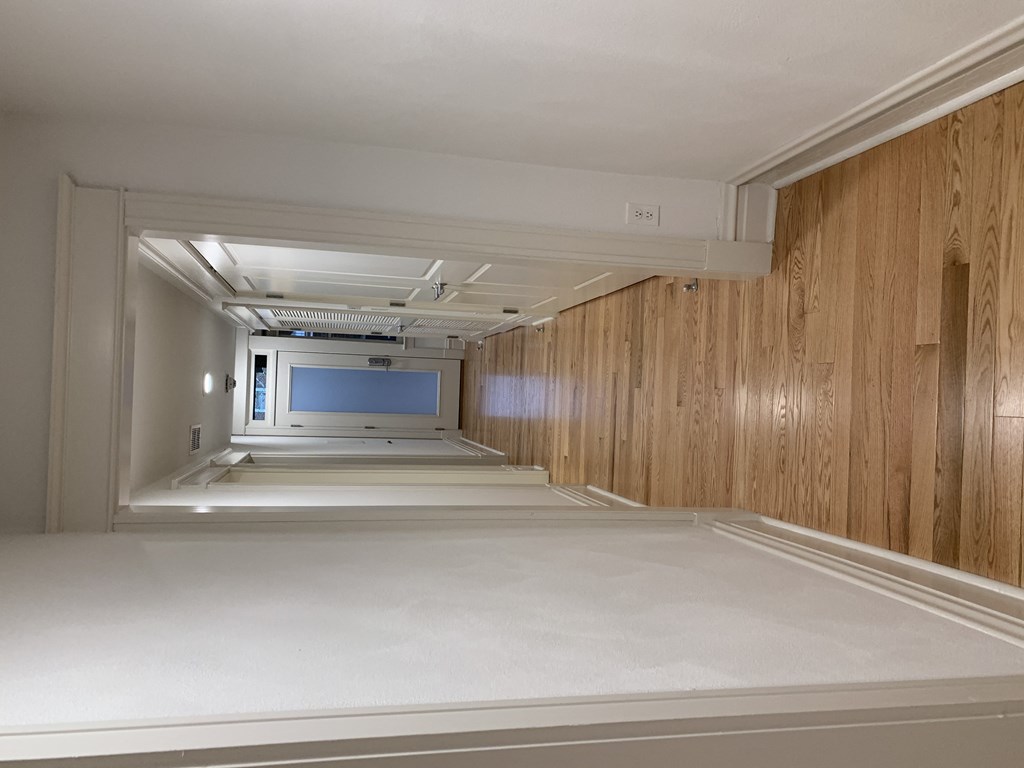 a hospital hallway with wood paneling and a tv on the wall