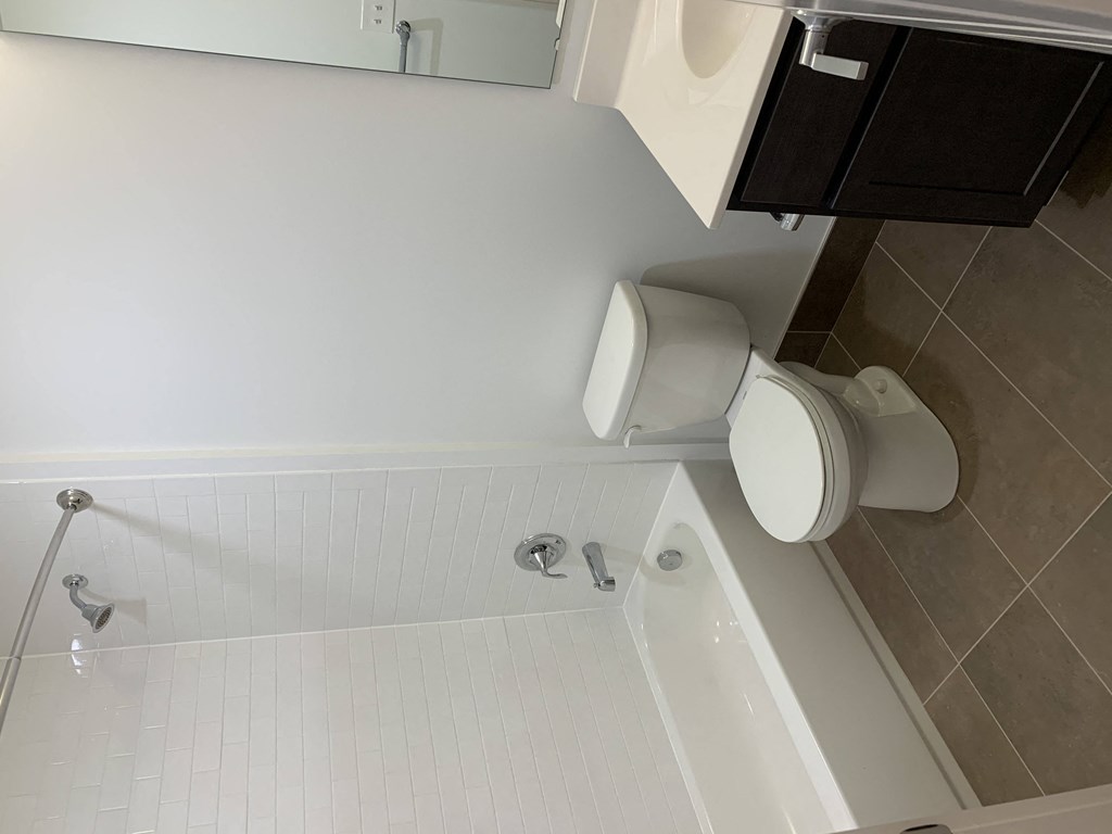 a bathroom with a toilet and a tub and a sink