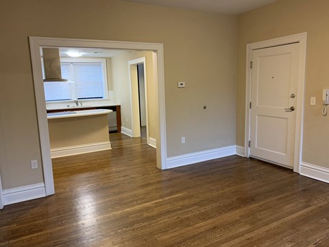 a living room and a kitchen with a wooden floor