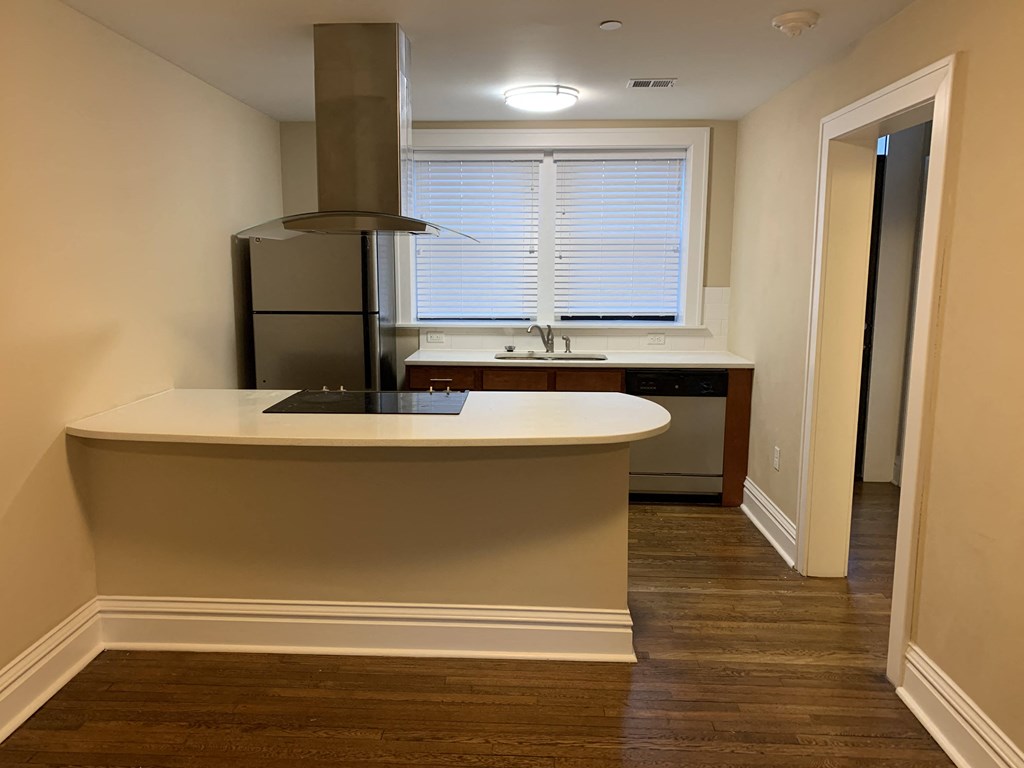 a kitchen with a white counter top and a window