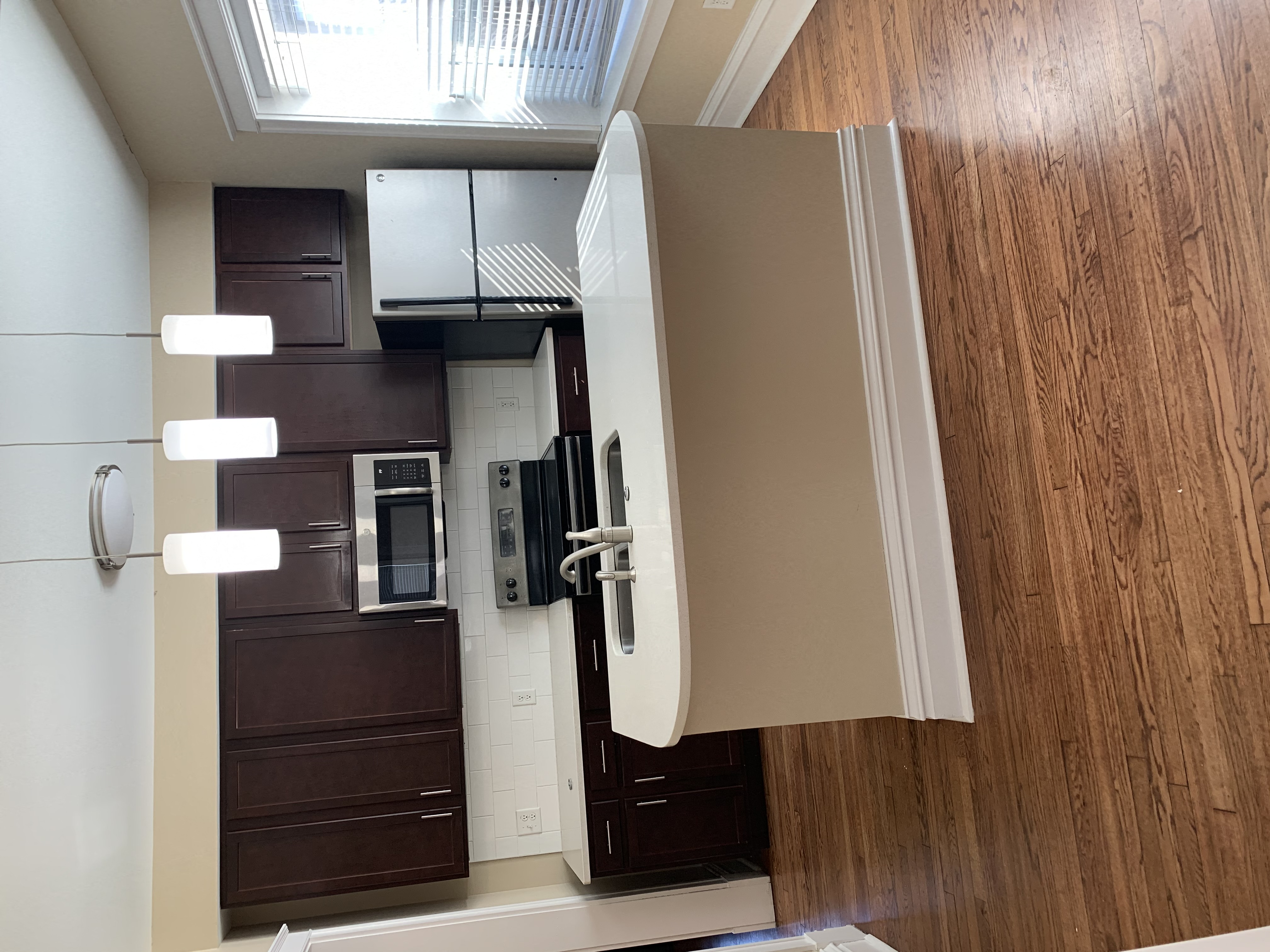 an open kitchen door with a refrigerator and a microwave