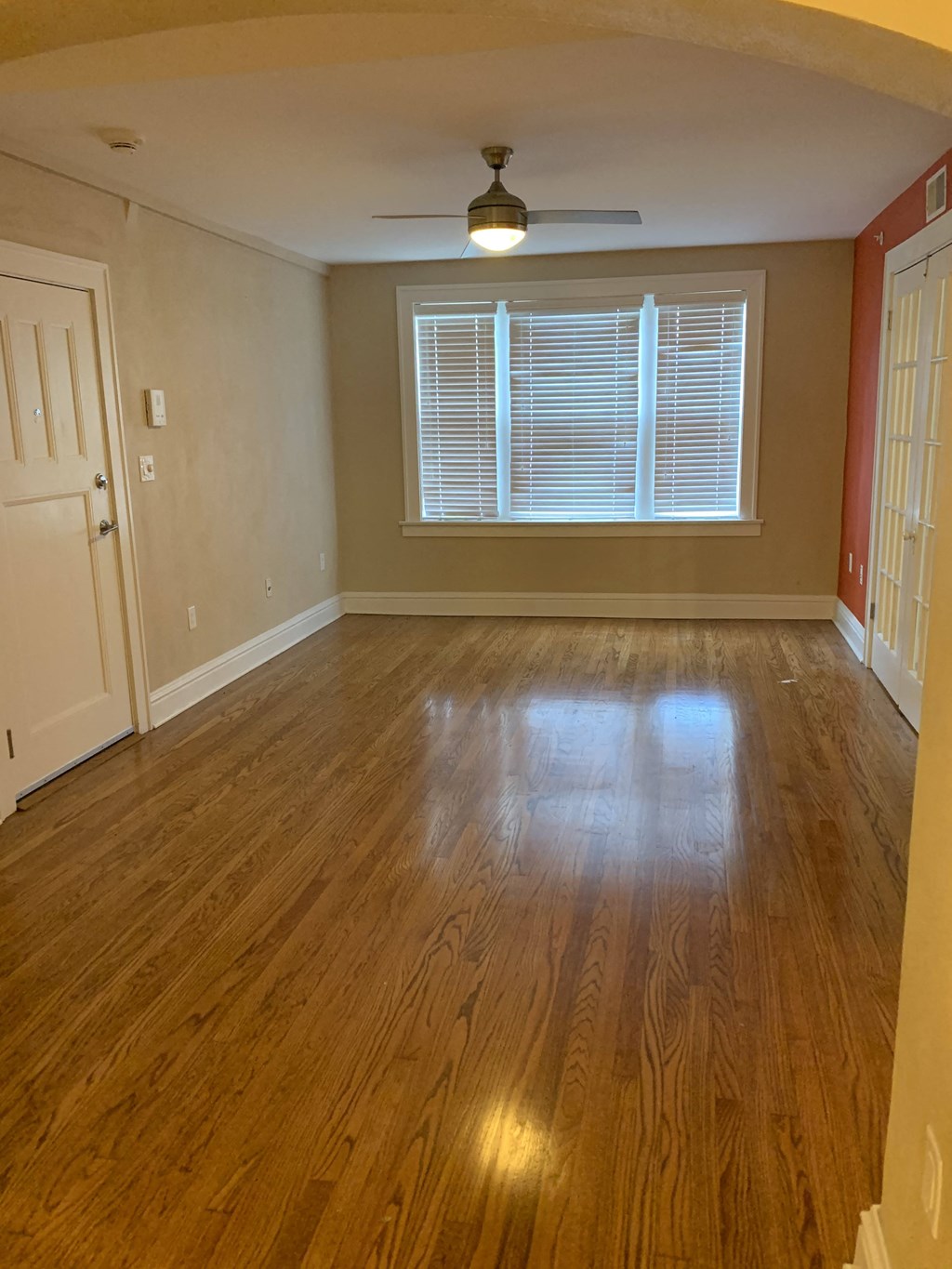 A room with wooden flooring and a ceiling fan.