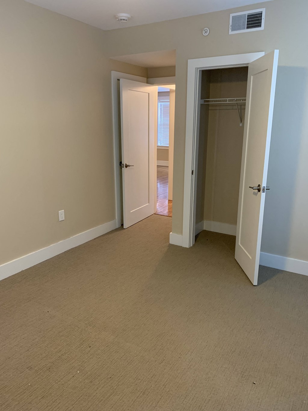 a bedroom with a closet and a hallway with an open door