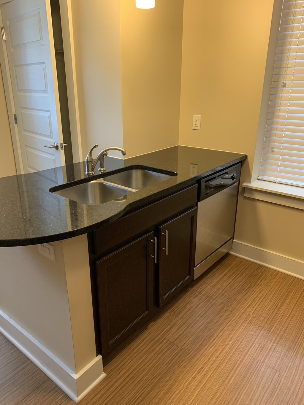 an empty kitchen with a sink and a window
