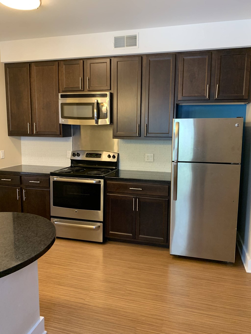 a kitchen with stainless steel appliances and dark wood cabinets