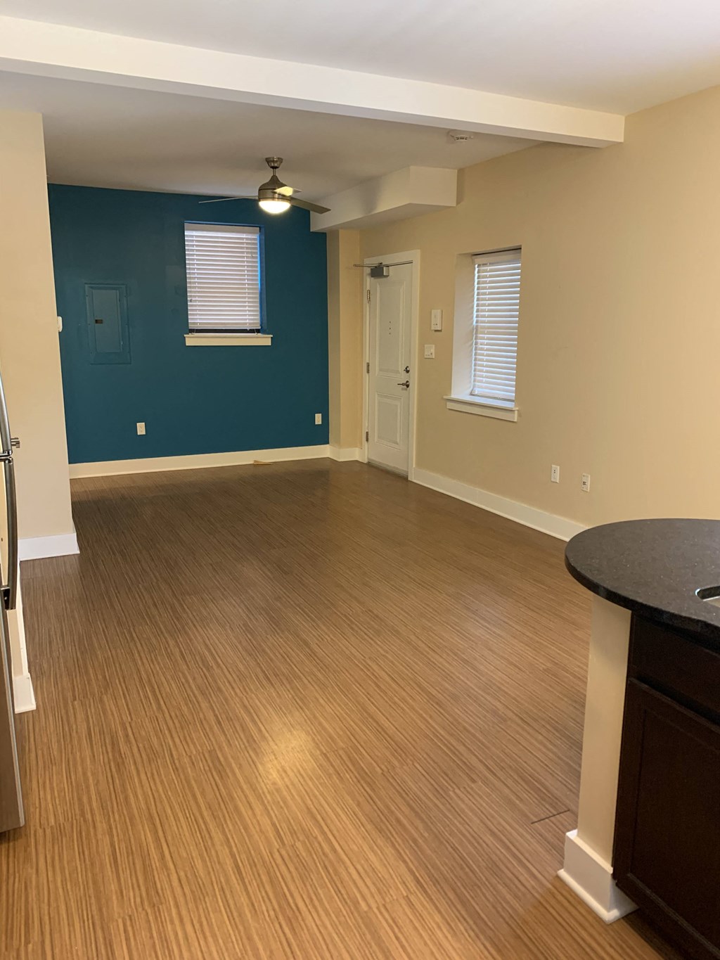 an empty living room with wood floors and a blue wall