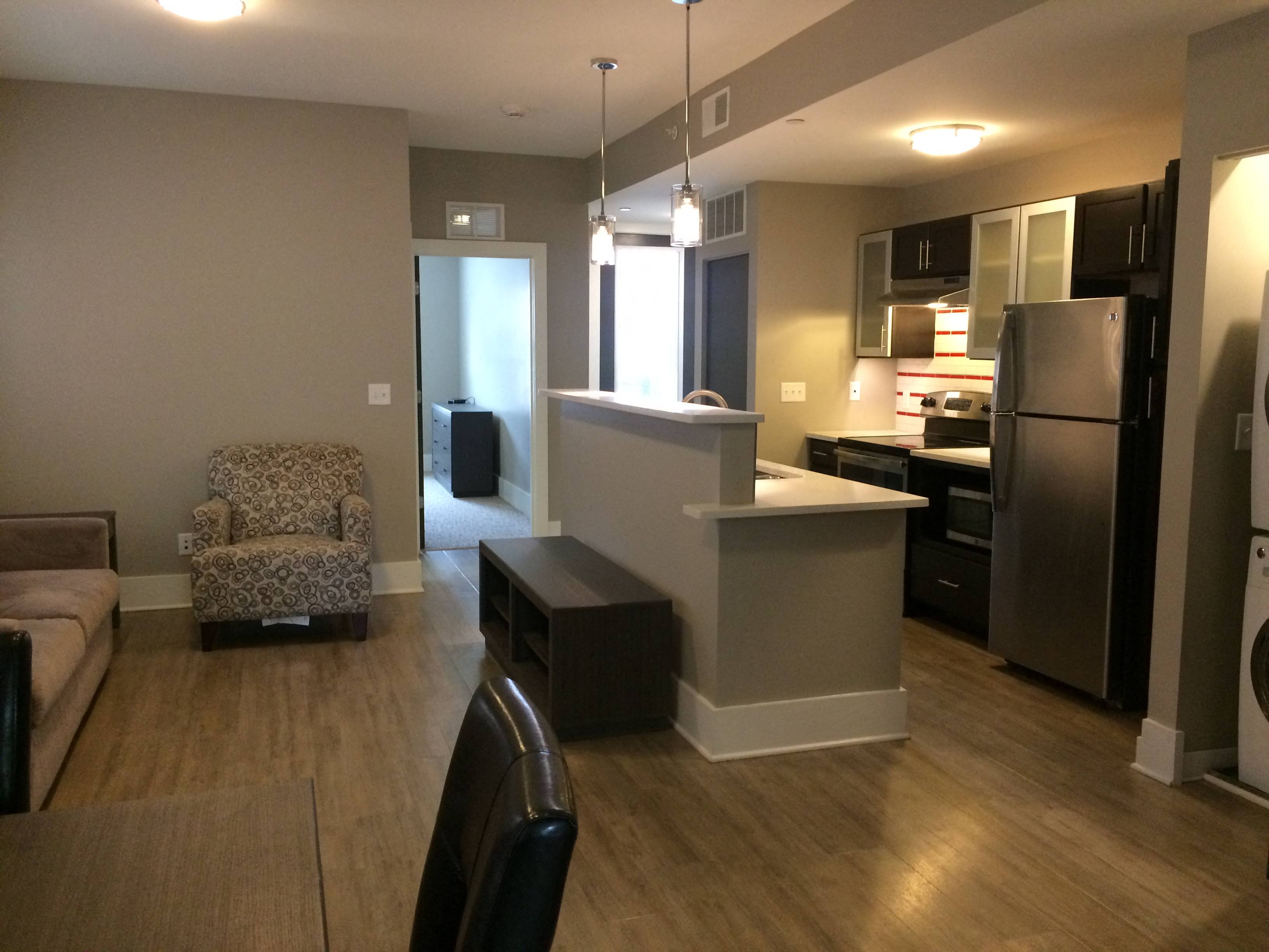 an open kitchen and living room with a table and a chair