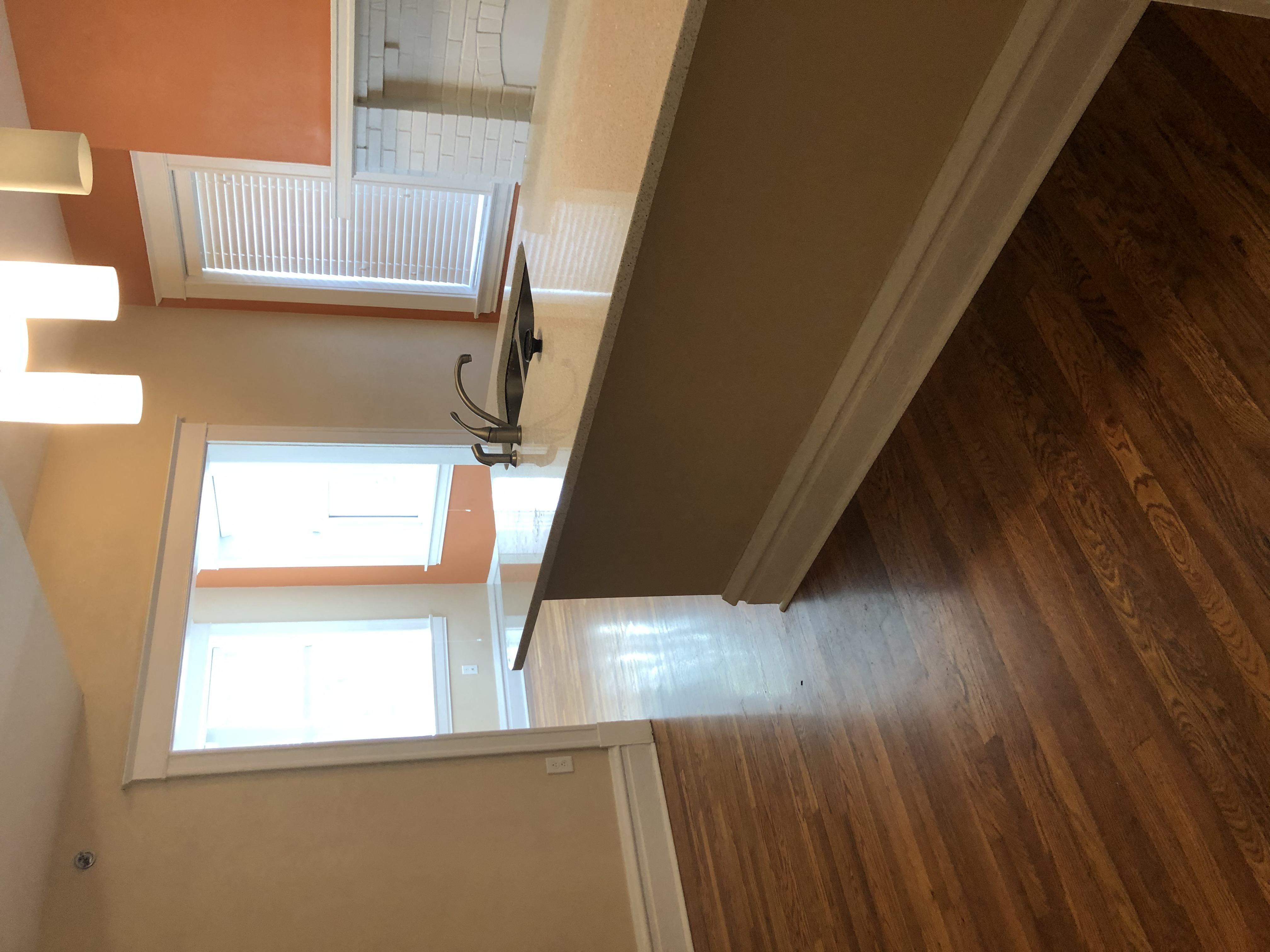 the view from the top of the stairs looking down into the living room and hallway
