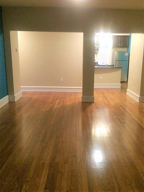 an empty living room with a hard wood floor