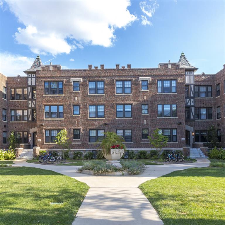 A large brick building with a courtyard in front.