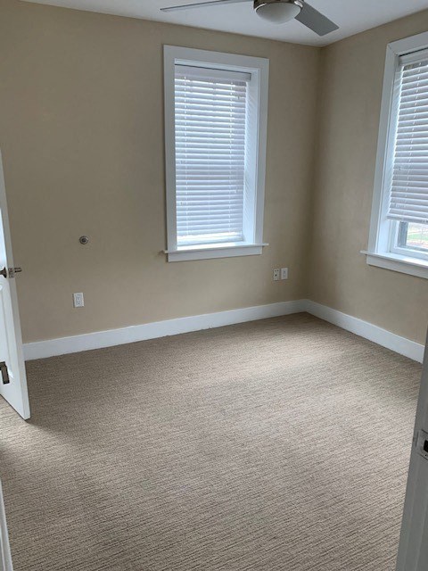 an empty room with two windows and a door