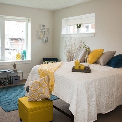 A bedroom with a bed, nightstand, and window.