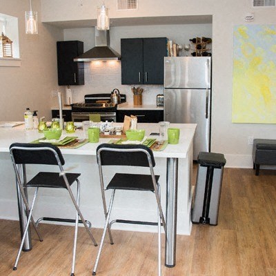 A kitchen with a white table and black chairs.