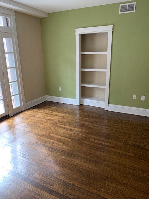 a living room with a wood floor and a book shelf
