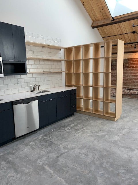 A kitchen with black cabinets and a white tiled backsplash.