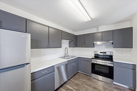 A kitchen with a white refrigerator and stainless steel appliances.