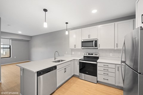 a renovated kitchen with white cabinets and stainless steel appliances