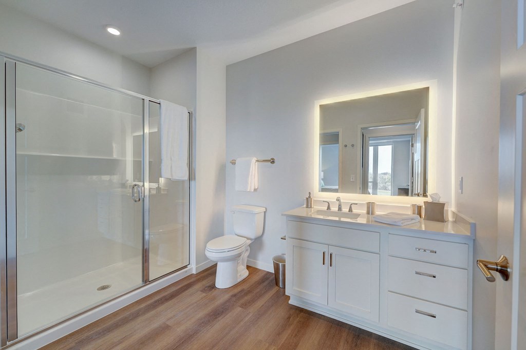 a white bathroom with a shower toilet and sink