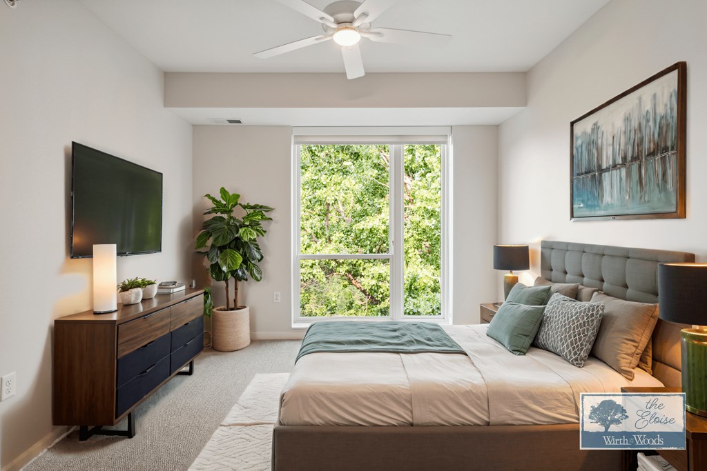 a bedroom with a bed and a large window