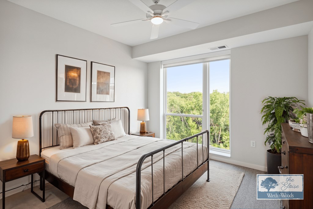 a bedroom with a bed and a large window