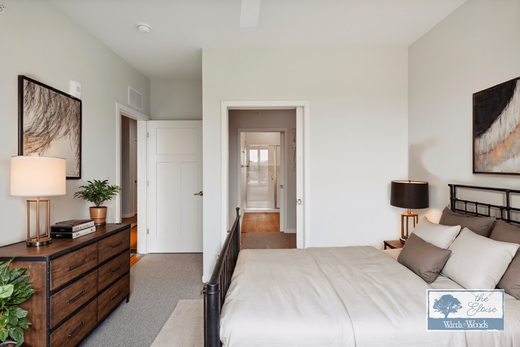 a bedroom with a bed and a dresser and a hallway