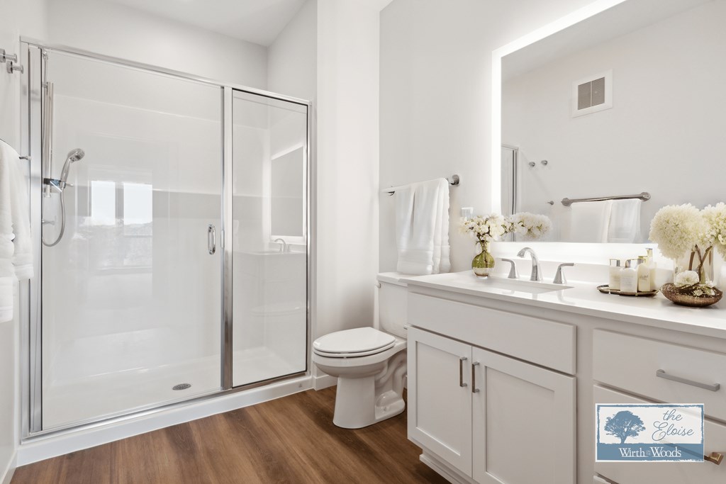 a white bathroom with a shower and a sink and a toilet