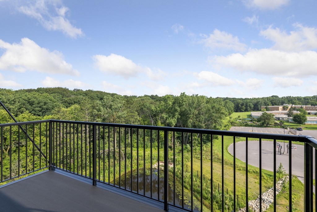 a balcony with a view of a field and trees