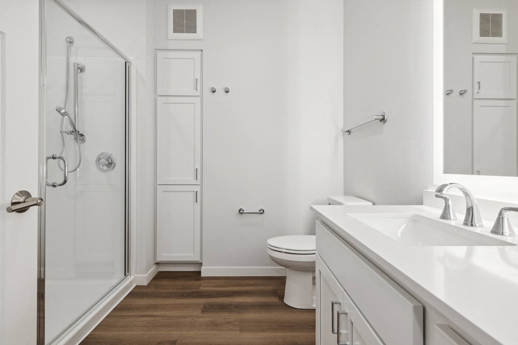 a bathroom with a toilet and a sink and a shower