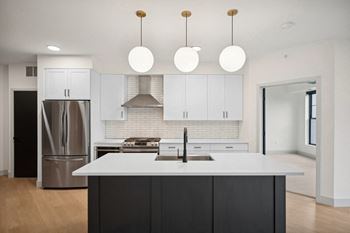 a large white kitchen with white cabinets and stainless steel appliances