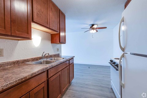 A kitchen with brown cabinets and a white refrigerator.