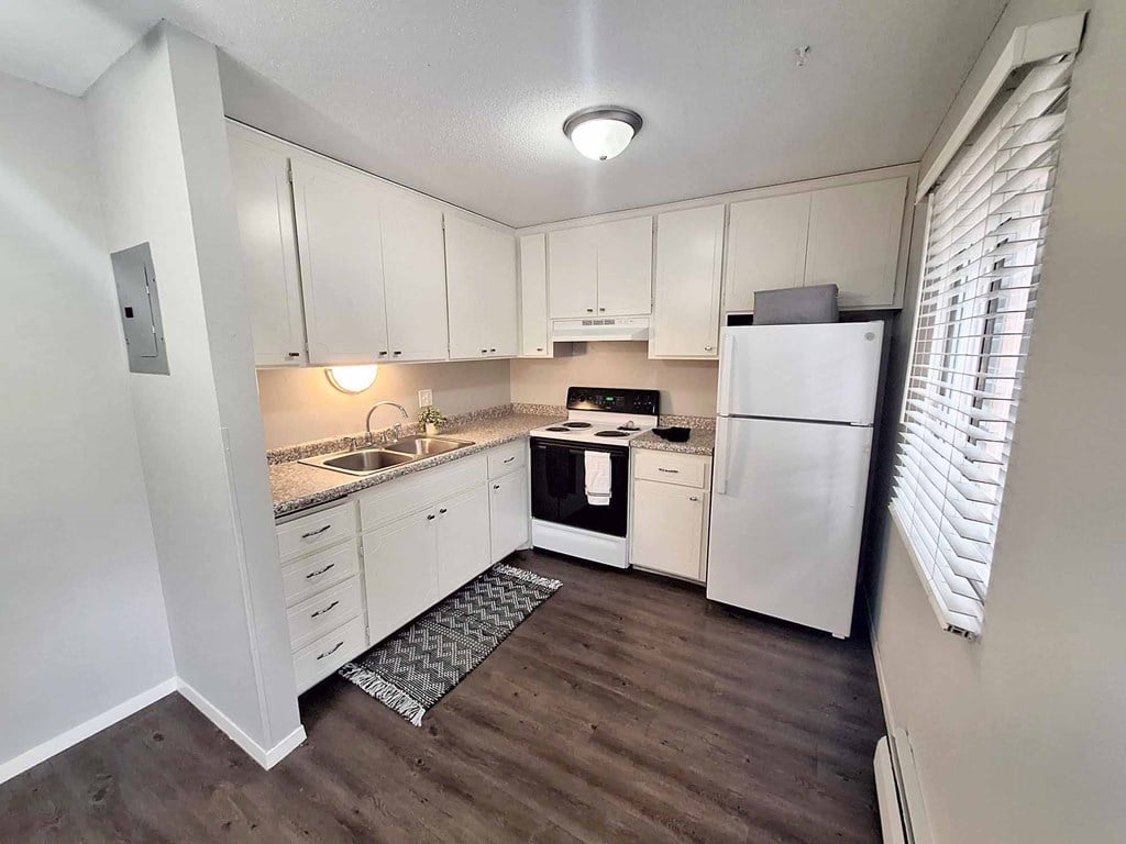 A kitchen with white appliances and cabinets.
