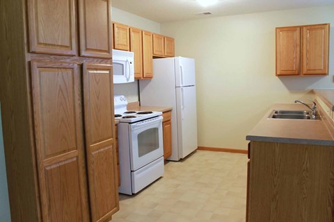 A kitchen with wooden cabinets and white appliances.