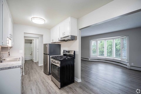 A kitchen with a black stove top oven and a white fridge.