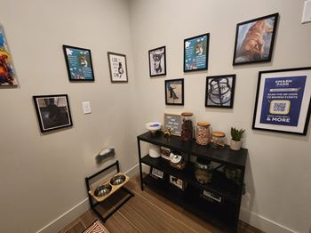 a corner of a room with pictures on the wall and a shelf