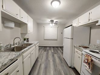 an empty kitchen with white cabinets and stainless steel appliances