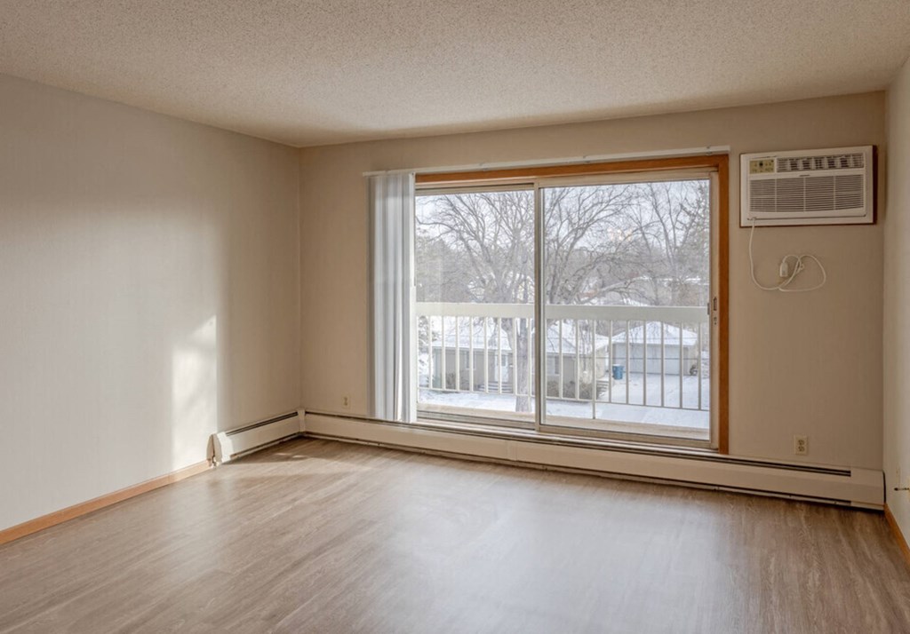 the living room of an empty house with a large window