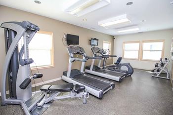 A spacious gym with treadmills, elliptical machines, and other exercise equipment.