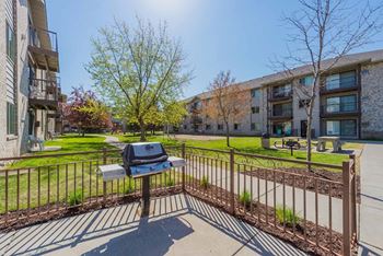 A sunny day in a residential area with a bench and a mailbox.