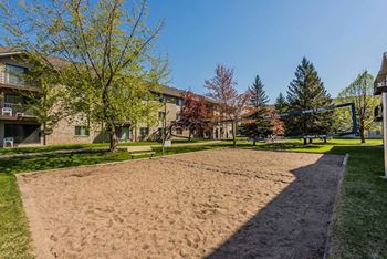A sandy area in front of apartment buildings.