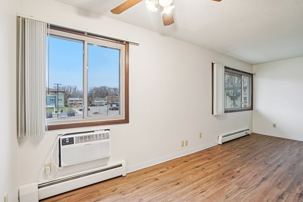 A room with a window and a fan on the ceiling.