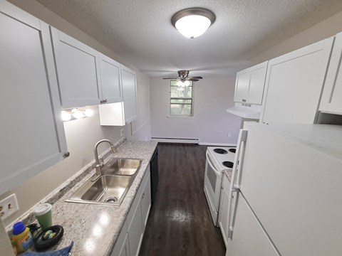 A kitchen with white cabinets and a sink.
