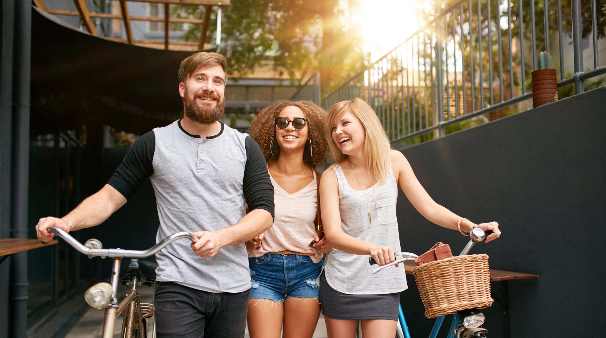 three people riding a bike down a street