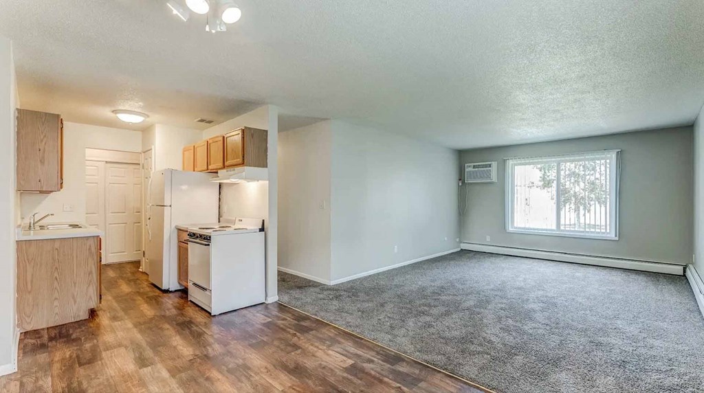 A kitchen with white appliances and wooden cabinets.