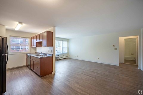 A kitchen with brown cabinets and a black refrigerator.